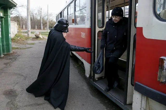 Darth Mykolaiovych Vader, who is dressed as the Star Wars character Darth Vader, poses for a picture as he tries to help a woman exit a tram in Odessa, Ukraine, December 3, 2015. (Photo by Valentyn Ogirenko/Reuters)