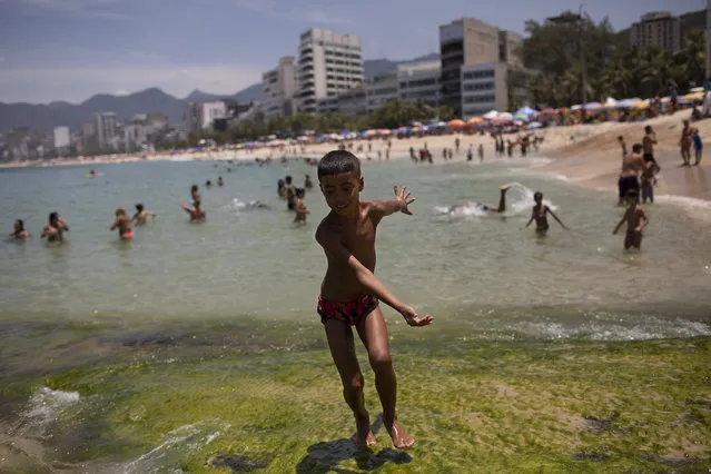 A youth runs on a rocky area of Ipanema beach in Rio de Janeiro, Brazil, Friday, January 29, 2021, amid the COVID-19 pandemic. (Photo by Silvia Izquierdo/AP Photo)
