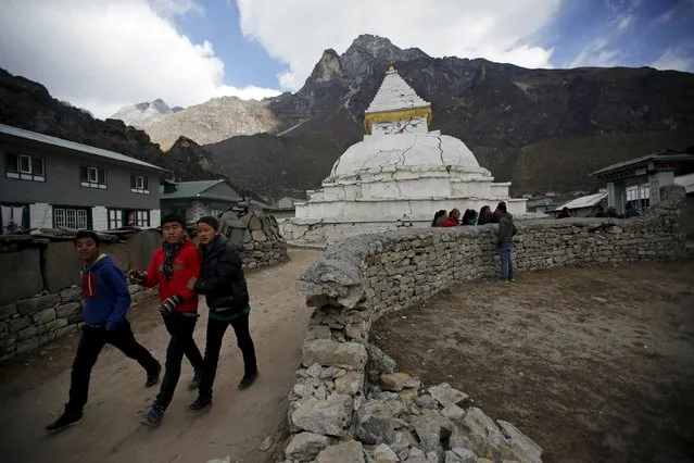 Children walk past the partially collapsed boundary wall of a school and a Buddhist shrine that were damaged during the earthquake earlier this year at Khumjung, a typical Sherpa village in Solukhumbu district also known as the Everest region, in this picture taken November 30, 2015. (Photo by Navesh Chitrakar/Reuters)