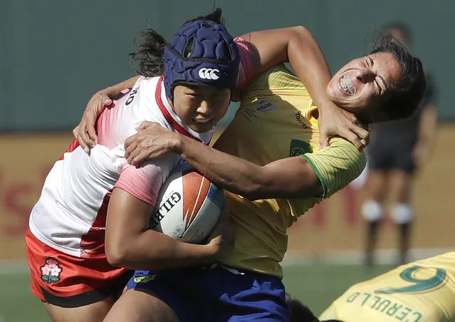 Japan's Noriko Taniguchi, left, runs against Brazil's Amanda Araujo during the Women's Rugby Sevens World Cup in San Francisco, Friday, July 20, 2018. (Photo by Jeff Chiu/AP Photo)