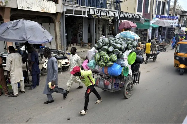 A man pushes a cart at a market in Kano, Nigeria, Thursday, July 13, 2023. (Photo by Sunday Alamba/AP Photo)