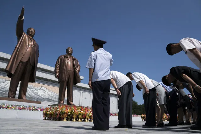In this Saturday, July 7, 2018, file photo, people pay their respects in front of bronze statues of the late leaders Kim Il Sung, left, and Kim Jong Il at Munsu Hill in Pyongyang, North Korea. North Korea marks the anniversary of Kim Il Sung's death on July 8. (Photo by Andrew Harnik/AP Photo)
