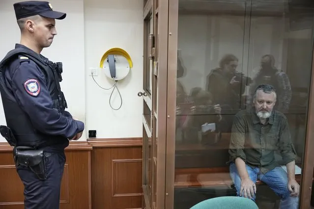 Igor Girkin also know as Igor Strelkov, the former military chief for Russia-backed separatists in eastern Ukraine, sits in a glass cage in a courtroom at the Moscow's City Court in Moscow, Russia, on Tuesday, August 29, 2023. A prominent Russian hard-line nationalist who accused President Vladimir Putin of weakness and indecision in Ukraine was detained on charges of extremism. (Photo by Alexander Zemlianichenko/AP Photo)
