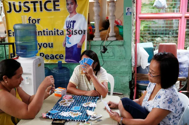 Relatives play cards at the wake of 22-year-old pedicab driver Eric Sison who was killed when, according to local officials, police were looking for drug pushers in Pasay city, Metro Manila in the Philippines August 29, 2016. (Photo by Erik De Castro/Reuters)