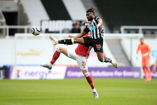 Newcastle's Allan Saint-Maximin, 10, competes for the ball with Arsenal's Calum Chambers during the English Premier League soccer match between Newcastle United and Arsenal at St James' Park stadium, in Newcastle, England, Sunday, May 2, 2021. (Photo by Lindsey Parnaby/Pool via AP Photo)