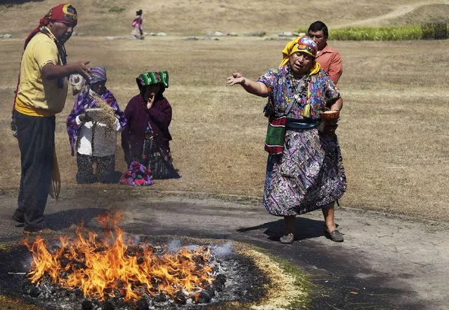 Mayan priests pour sugar over a sacred fire lit from sugar, tree resin, and bread, during a ceremony marking the Mayan new year which begins on Saturday, in the Kaminaljuyu archaeological zone in Guatemala City February 21, 2015. (Photo by Jorge Dan Lopez/Reuters)