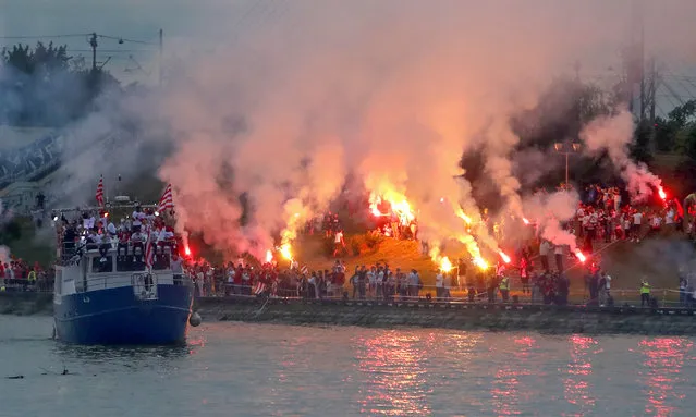A boat with players cruises on Sava river as Red Star fans celebrate after their team won the Serbian soccer league title in Belgrade, Serbia, Saturday, May 22, 2021. (Photo by Darko Vojinovic/AP Photo)
