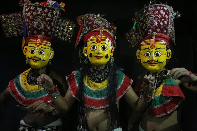 In this September 23, 2018, photo, dancers pose for photographs wearing the mask of god Betal in Kathmandu, Nepal. (Photo by Niranjan Shrestha/AP Photo)