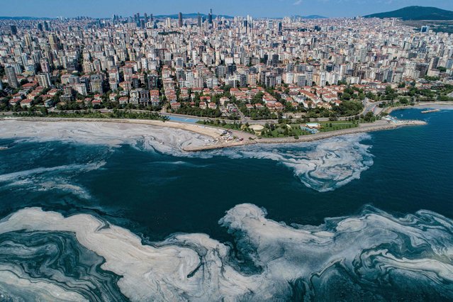 This aerial photograph taken on June 6, 2021 in Turkey's Marmara Sea at a harbor on the shoreline of Istanbul shows mucilage, a jelly-like layer of slime that develops on the surface of the water due to the excessive proliferation of phytoplankton, gravely threatening the marine biome. The mucilage has been informally referred to as “sea snot” and was first documented in Turkey's waters in 2007. Experts warn the mucilage will occur more often because of global warming. (Photo by Yasin Akgul/AFP Photo)
