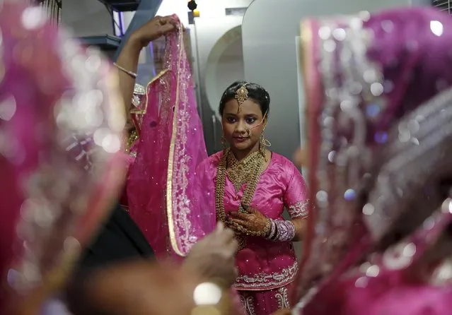 A Muslim bride gets ready as others wait at a beauty parlour before the start of a mass marriage ceremony in Mumbai, India, January 27, 2016. (Photo by Danish Siddiqui/Reuters)