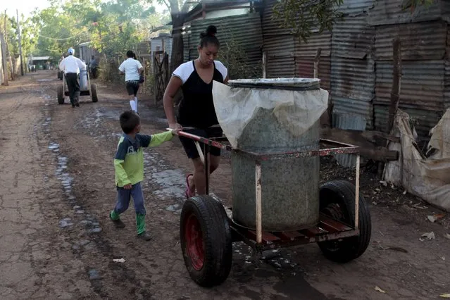 A woman pushes her cart, as she collects potable water from a public well on the outskirts of Managua March 20, 2015. (Photo by Oswaldo Rivas/Reuters)