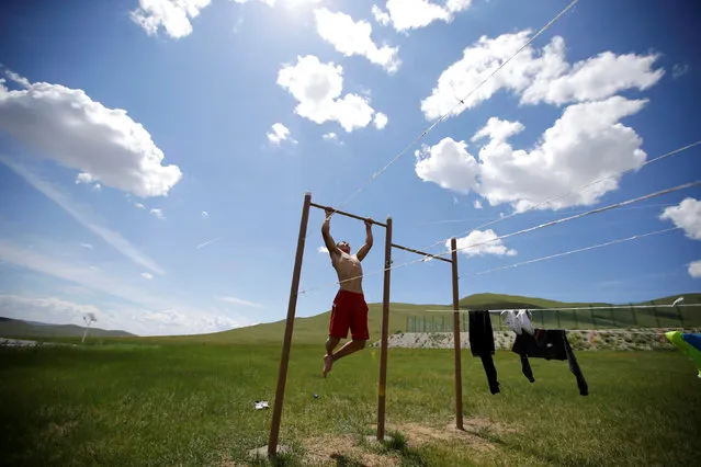 MONGOLIA: A training partner of Mongolia's Olympic wrestler team does pull-ups after a daily training session outside the Mongolia Women's National Wrestling Team training center in Bayanzurkh district of Ulaanbaatar, Mongolia, July 1, 2016. (Photo by Jason Lee/Reuters)