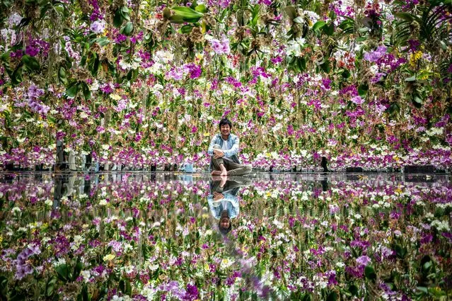 Toshiyuki Inoko, leader of TeamLab, poses for a photo following an interview with AFP in an interactive kinetic installation “Floating Flower Garden: Flowers and I are of the Same Root, the Garden and I are One” during a media preview of the TeamLab Planets Garden Area in the Toyosu district of Tokyo on June 29, 2021. (Photo by Philip Fong/AFP Photo)
