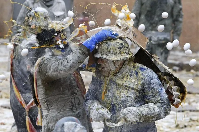 People known as “els enfarinats” (the floured ones) take part in a flour and eggs battle as each year in the village of Ibi, Alicante, eastern Spain, 28 December 2016. Traditionally, els enfarinats “capture” the city by means of several battles with flour, eggs and firecrackers as part the town's winter feast. (Photo by EPA/Morell)