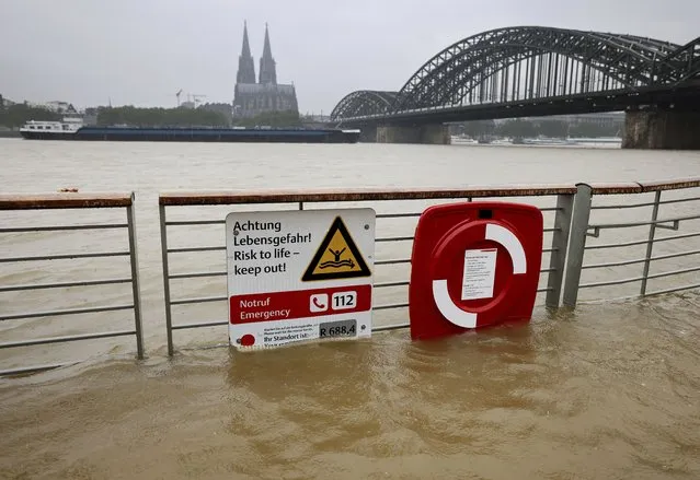 The river Rhine floods the promenade in Cologne, Germany, Tuesday, July 13, 2021. Thunderstorms and lots of rain are expected in North Rhine-Westphalia over the next few days. (Photo by Oliver Berg/dpa via AP Photo)
