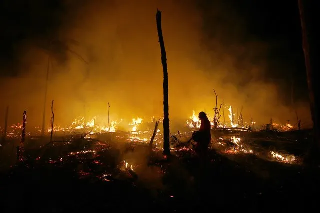 Firefighters work to put out a blaze in the Amazon forest during a drought and high temperatures in the rural  municipality of Careiro Castanho, Amazonas state, Brazil, Saturday, October 21, 2023. (Photo by Edmar Barros/AP Photo)