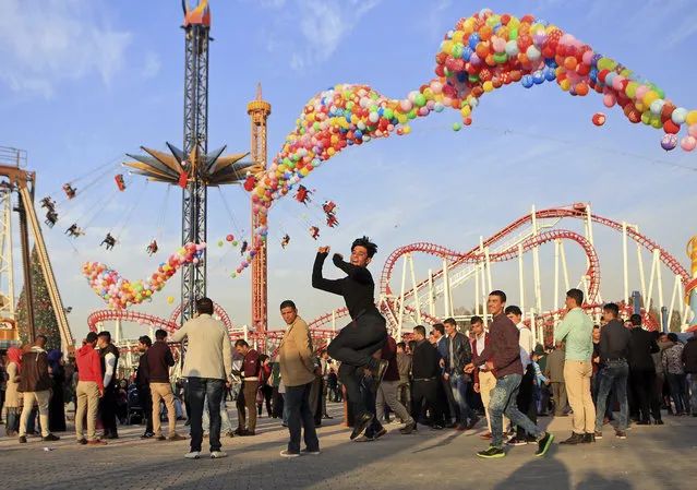 Iraqis celebrate Valentine's Day at al-Zawra Park in Baghdad, Iraq, Sunday, February 14, 2016. The city is plastered with Valentine hearts and roses, and Iraqis are enjoying a rare lull in violence but wondering how long it will last. Despite recent setbacks, the Islamic State group is still dug in west of Baghdad, and increasingly powerful Shiite militias patrol the streets. (Photo by Khalid Mohammed/AP Photo)