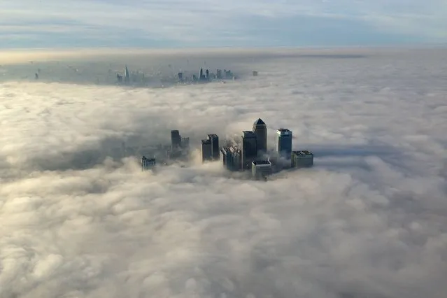 The Canary Wharf business district of east London taken from the Metropolitan Police helicopter is seen during a foggy morning in this photograph received via the Metropolitan Police in London, on December 12, 2013. (Photo by Metropolitan Police@MPSintheSky via Reuters)