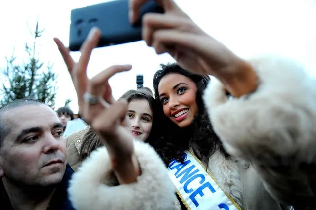 Miss France 2014 Flora Coquerel shoots a picture with a fan during a welcoming ceremony held at her home place on December 18, 2013, in Morancez, center France. (Photo by Jean-Francois Monier/AFP Photo)