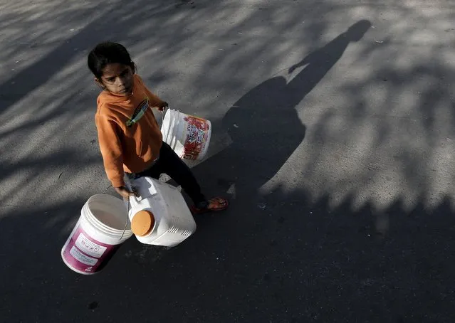 A girl carries empty containers to fetch water from a municipal water tap in New Delhi, India, February 21, 2016. India deployed thousands of troops in a northern state on Sunday to quell protests that have severely hit water supplies to Delhi, a city of more than 20 million people, forced factories to close and killed 10 people. (Photo by Anindito Mukherjee/Reuters)