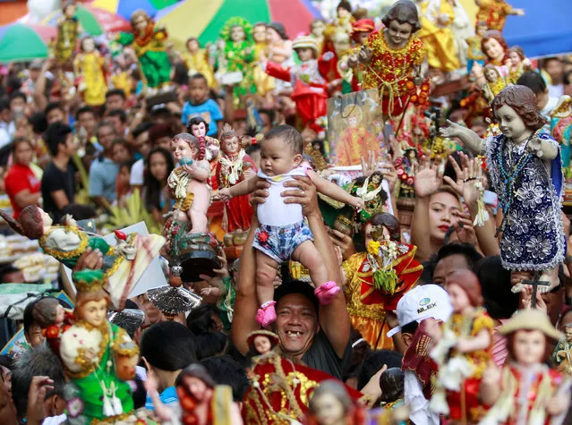 A devotee carries his child to be blessed by the lay minister with holy water during the annual feast of Sto. Nino (Holy Child Jesus) in Manila, Philippines January 15, 2017. (Photo by Czar Dancel/Reuters)
