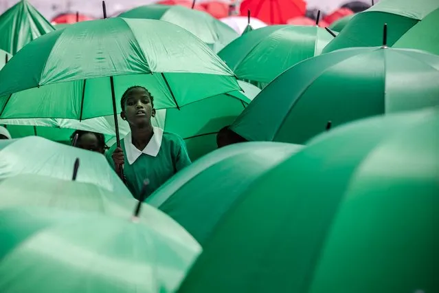 Kenyan students hold umbrellas to protect themselves from the sun during the celebrations of Kenya's 60th Independence Day, also known as Jamhuri Day, at the Uhuru Gardens in Nairobi on December 12, 2023. Jamhuri is the Swahili word for “republic”, and the national holiday officially marks the date when Kenya became an independent country from the United Kingdom on December 12, 1963. (Photo by Luis Tato/AFP Photo)
