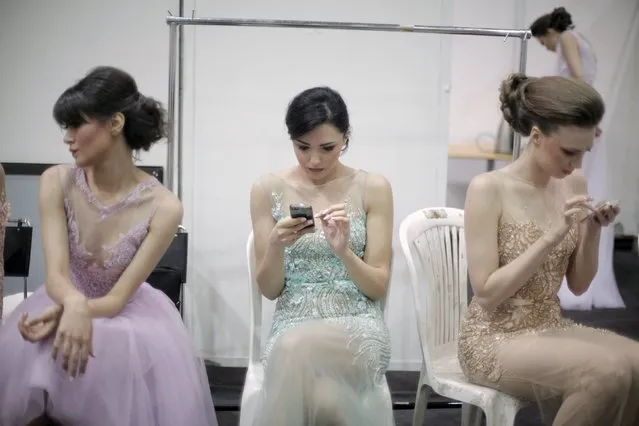 Models use their smartphones backstage prior to a fashion show by Lebanese designer Abed Mahfouz during Spring-Summer 2015 in Beirut April 29, 2015. (Photo by Alia Haju/Reuters)