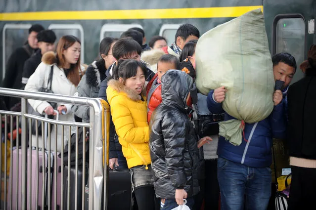 People carry their luggage as they board trains on the last day of the Chinese Lunar New Year holidays, at a railway station in Bozhou, Anhui province, February 2, 2017. (Photo by Reuters/Stringer)