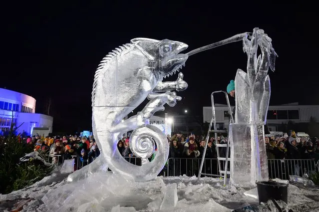 An artist at work during the International Ice Sculpture Festival at the Poznan International Fair area in Poznan, Poland, 11 December 2022. (Photo by Jakub Kaczmarczyk/EPA/EFE)