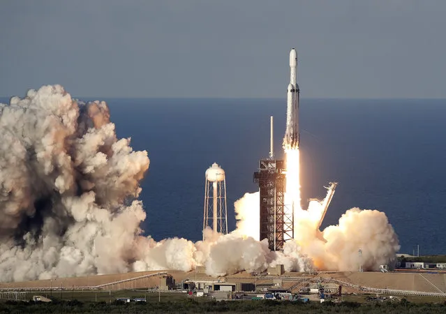 A SpaceX Falcon Heavy rocket carrying a communication satellite lifts off from pad 39A at the Kennedy Space Center in Cape Canaveral, Fla., Thursday, April 11, 2019. (Photo by John Raoux/AP Photo)