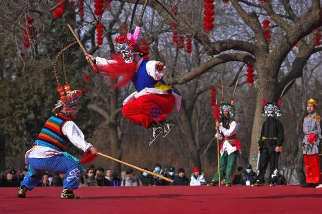 Chinese artists dressed in traditional costumes perform an acrobatic show on stage at the Longtan Park's temple fair on the second day of Lunar New Year in Beijing, Sunday, February 11, 2024. (Photo by Andy Wong/AP Photo)