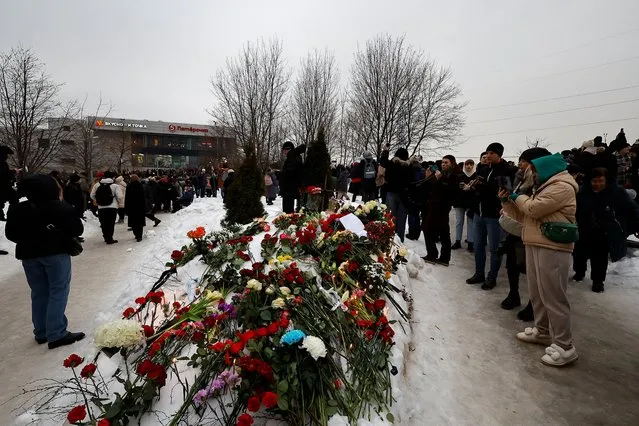 People lay flowers near the Borisovskoye cemetery after the funeral of Russian opposition politician Alexei Navalny, in Moscow, Russia, on March 1, 2024. (Photo by Reuters/Stringer)