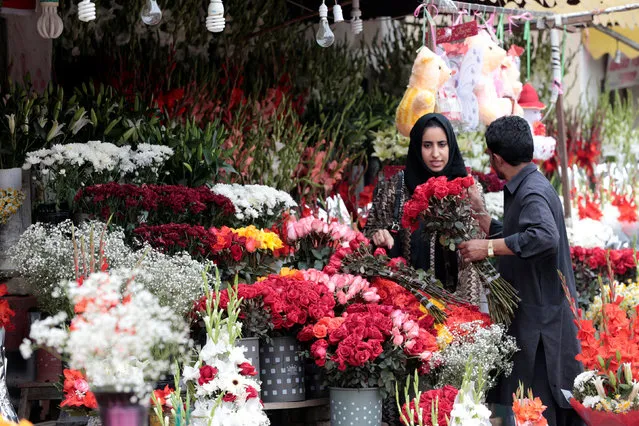 A woman buys flowers at a flower market in Islamabad, Pakistan February 14, 2017. (Photo by Caren Firouz/Reuters)