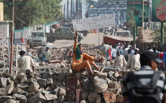 A Sudanese protester makes victory sign as he sits on a barricade on a road leading to the defense ministry compound in Khartoum, Sudan, April 30, 2019. (Photo by Umit Bektas/Reuters)