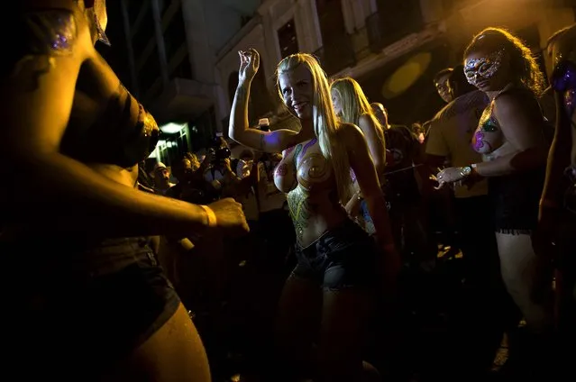 Women wearing body paint dance at the “Rua do Mercado” band Carnival parade in Rio de Janeiro, February 27. The women said they were topless to defend the right of women to be topless on Rio's beaches, as they joined one of many parades before the official start of Carnival on February 28. (Photo by Silvia Izquierdo/Associated Press)