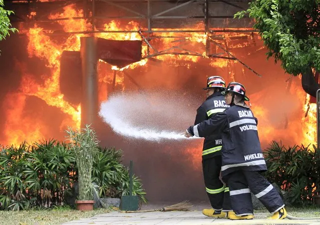 Firefighters use a fire hose to put out a fire as it razes the College of Arts and Sciences building of the University of the East in Manila April 2, 2016. Authorities are investigating the cause of the fire, local media reported. (Photo by Romeo Ranoco/Reuters)