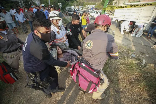 An injured migrant woman is moved by rescue personnel from the site of an accident near Tuxtla Gutierrez, Chiapas state, Mexico, December 9, 2021. (Photo by AP Photo/Stringer)