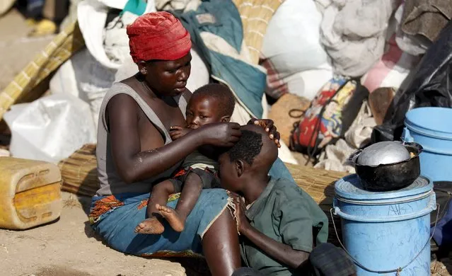 A Burundian refugee shaves her son as they gather on the shores of Lake Tanganyika in Kagunga village in Kigoma region in western Tanzania with their belongings, as they wait for MV Liemba to transport them to Kigoma township, May 17, 2015. (Photo by Thomas Mukoya/Reuters)