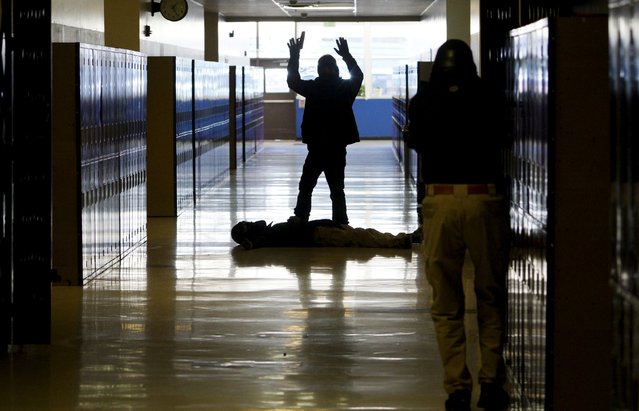 A student confronts a shooter with a mock victim on the floor in a middle school during an Active Shooter Response course offered by TAC ONE Consulting in Denver, Colorado April 2, 2016. According to TAC ONE, the course, which is offered for the first time to concealed weapons permit carrying civilians, is designed at preparing people to effectively save lives prior to the arrival of law enforcement at an active shooter incident. (Photo by Rick Wilking/Reuters)