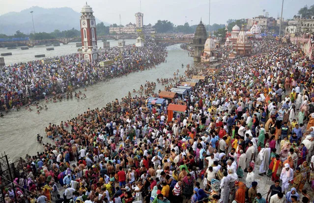 Hindu devotees gather on the banks of the River Ganges to take holy dips on the auspicious occasion of Somvati Amavasya in Haridwar, India, Monday, May 18, 2015. Somvati Amavasya is the no moon day that falls on a Monday in a traditional Hindu lunar calendar. It is a rare occurrence in a year and is considered highly auspicious. (Photo by Sandeep Sharma/AP Photo)