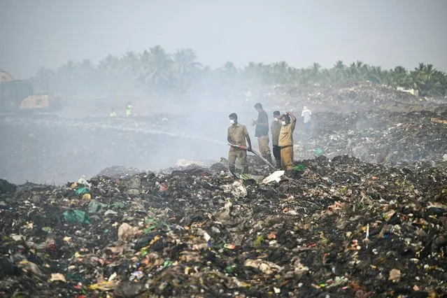 Workers douse a fire at Vellalore dump yard in Coimbatore on April 12, 2024. (Photo by R.Satish Babu/AFP Photo)