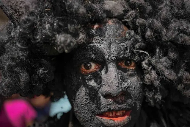 A man dressed as a “bolero” eyes the camera during festivities marking Holy Innocents Day which commemorates King Herod's infanticide of baby boys in Bethlehem after the birth of Jesus according to the Gospel of Matthew, in Caucagua, Venezuela, Tuesday, December 28, 2021. (Photo by Matias Delacroix/AP Photo)