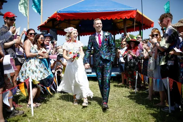 Jack Watney and Sarah Adney celebrate after getting married during Glastonbury Festival at Worthy farm in Somerset, Britain on June 27, 2019. (Photo by Henry Nicholls/Reuters)