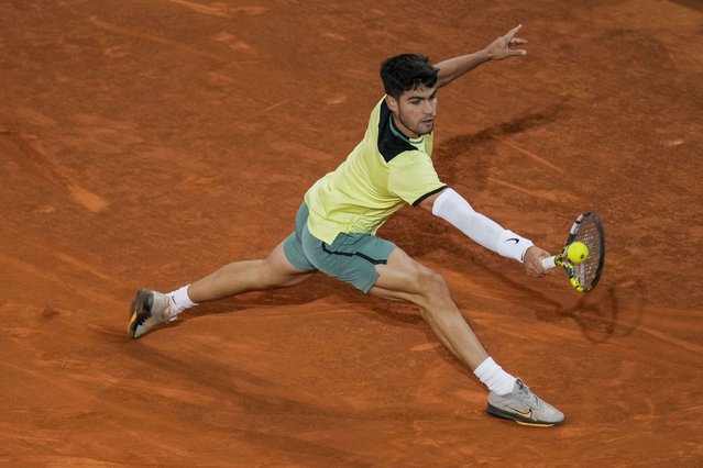 Carlos Alcaraz, of Spain, returns the ball to Andrey Rublev, of Russia, during the Mutua Madrid Open tennis tournament in Madrid, Wednesday, May 1, 2024. (Photo by Manu Fernandez/AP Photo)