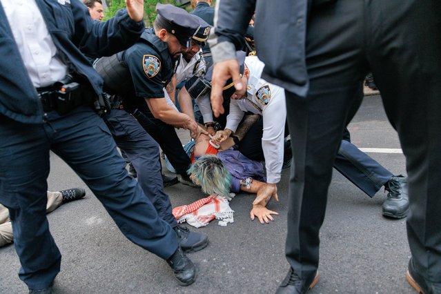 NYPD officers detain a protester during the Met Gala in New York on May 6, 2024. (Photo by Jeenah Moon for The Washington Post)