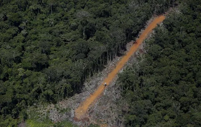 A helicopter patrols an illegal lane used by miners during Brazil’s environmental agency operation against illegal gold mining on indigenous land, in the heart of the Amazon rainforest, in Roraima state, Brazil April 17, 2016. (Photo by Bruno Kelly/Reuters)