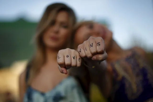Cherilyn Wilson, 26, (L) and Chelsea Kane, 26, display their fists, with the message “Love Wins” written on them, as they pose at a celebration rally in West Hollywood, California, United States, June 26, 2015. (Photo by Lucy Nicholson/Reuters)