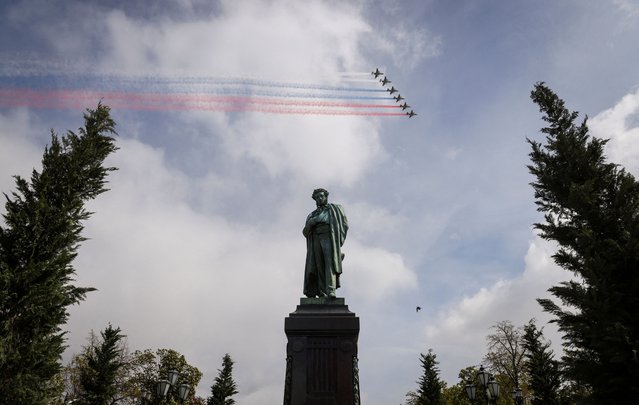 Russian Su-25 jet aircraft release smoke in the colours of the Russian state flag over the monument to Russian poet Alexander Pushkin during a flypast and a military parade on Victory Day, which marks the 79th anniversary of the victory over Nazi Germany in World War Two, in Moscow, Russia on May 9, 2024. (Photo by Marina Lystseva/Reuters)