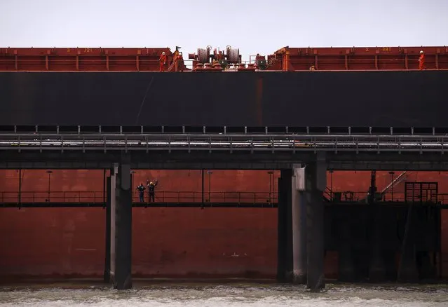 Port workers load a ship with coal at the RG Tanna Coal Terminal located at the town of Gladstone in Queensland, Australia, June 12, 2015. (Photo by David Gray/Reuters)