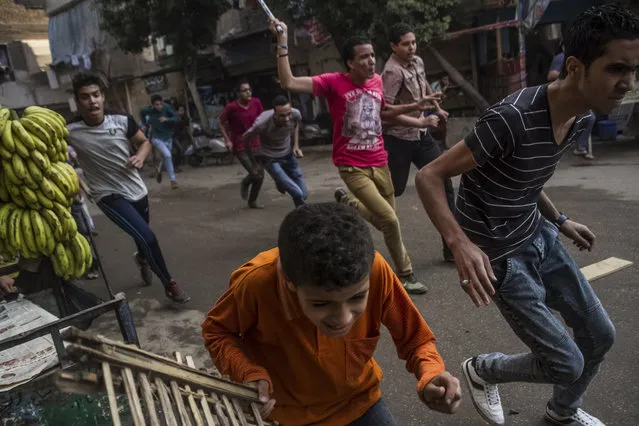 Supporters of the Muslim Brotherhood and bystanders run away from the Egyptian security forces during clashes following their protest on a street in Cairo's Matariya district, Egypt, Tuesday, June 30, 2015. Protesters were marching on a Cairo street Tuesday as authorities has declared the day a national holiday, two years after the mass protests that preceded the overthrow of President Mohammed Morsi. (Photo by Belal Darder/AP Photo)